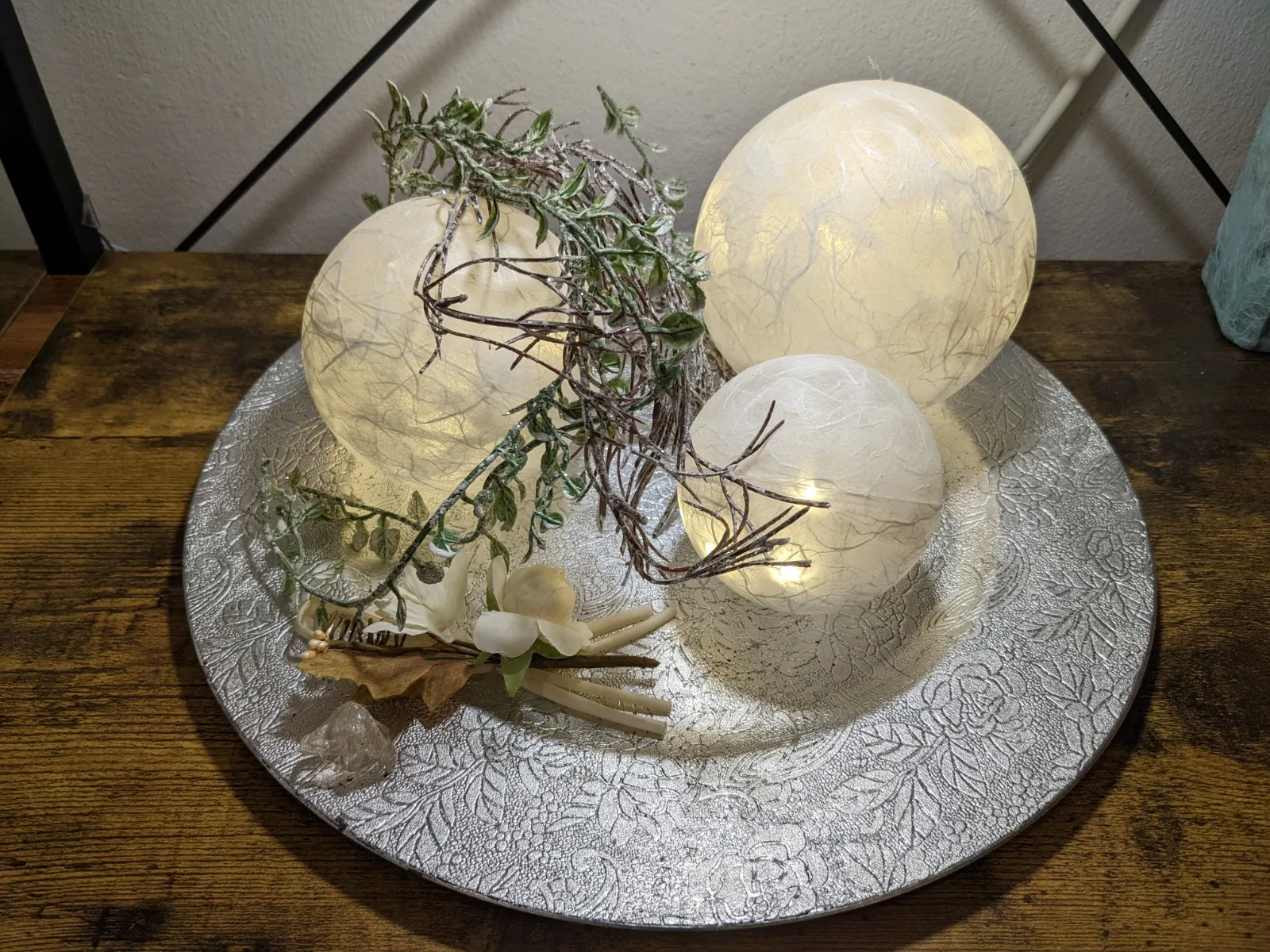 Dekoratives Set aus weißen Lichtkugeln und Naturmaterialien